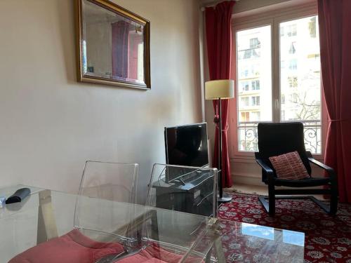 un salon avec une table en verre et une télévision dans l'établissement Lumineux appartement de 47m2 dans le 17eme, à Paris