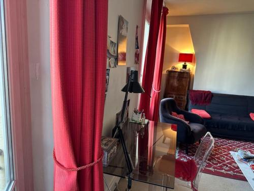 - un salon avec un canapé bleu et des rideaux rouges dans l'établissement Lumineux appartement de 47m2 dans le 17eme, à Paris
