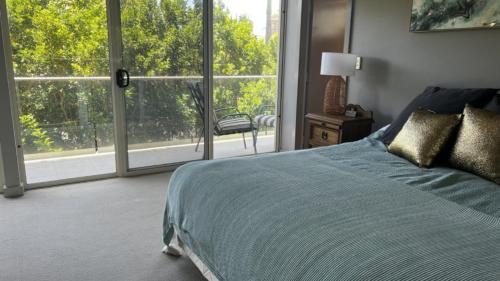 a bedroom with a bed and a large window at Myall Views From Majestic #7 in Hawks Nest