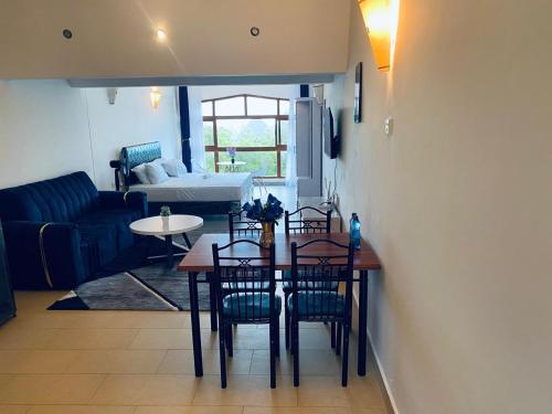 a dining room with a table and chairs and a living room at Seabreeze suites Villa in Diani Beach