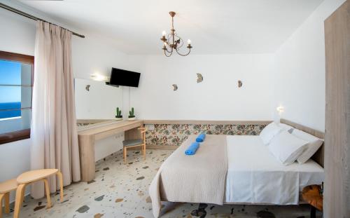 a bedroom with a bed and a desk with a computer at KRANA Hotel in Líndos