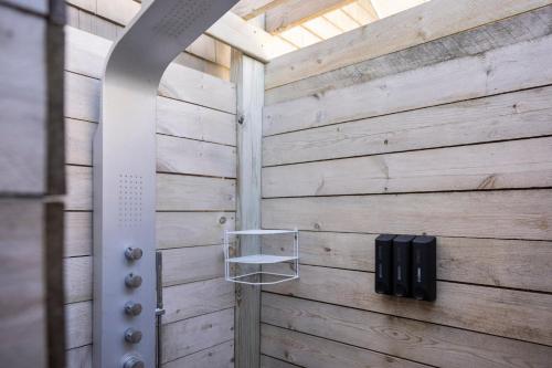 a bathroom with a wooden wall with a shelf at Stunning Newly Renovated Modern Beach House - 7633 in Cedar