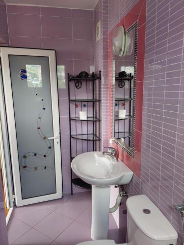ein rosafarbenes Bad mit einem Waschbecken und einem WC in der Unterkunft Accommodation Royal Azur in Dobra Voda