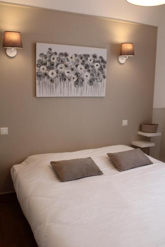 sypialnia z białym łóżkiem z 2 poduszkami w obiekcie Coliwork Le Saint Romain w mieście Dangé