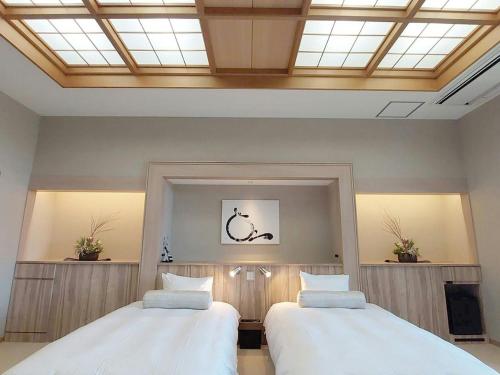 two beds in a room with a skylight at Ikoi no Mura Heritage Minoyama in Minano