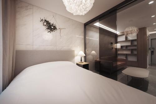 a bedroom with a large white bed and a chair at Wecostay Gangnam in Seoul