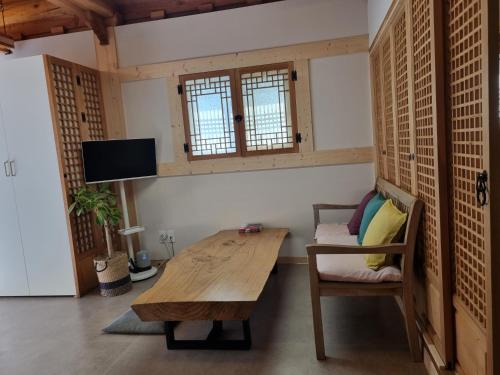 a living room with a wooden table and a chair at Naru Hanok stay in Jeonju