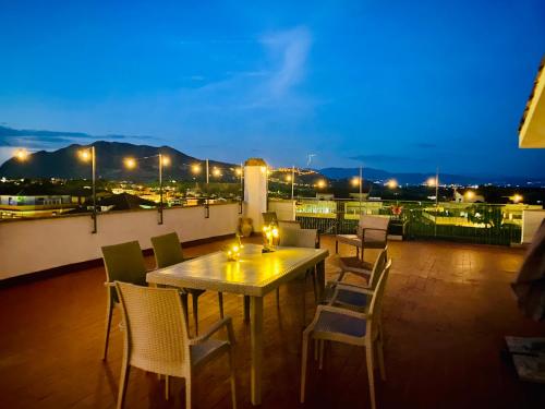 una mesa y sillas en un balcón por la noche en Way2Rome Apartments, en Rignano Flaminio