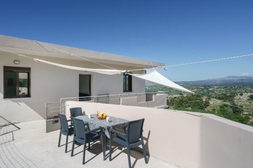 a table and chairs on the balcony of a house at Patima Hills in Chania Town