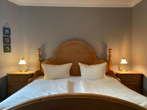 a bedroom with a bed with two lamps on two tables at Haus Alpendomizil - Sommer-Bergbahnen kostenlos in Bolsterlang