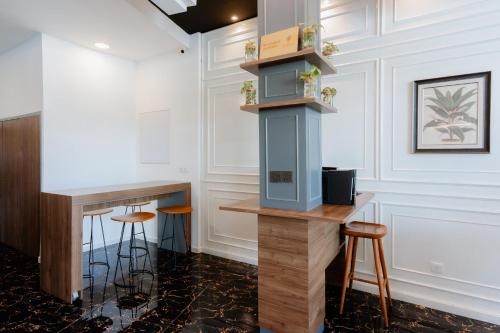 een bar met krukken in een kamer met witte muren bij Midori Concept Hotel in Johor Bahru