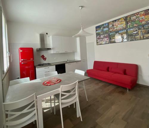 een woonkamer met een tafel en een rode bank bij Mo&Ma Home in Imola