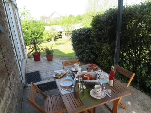 una mesa con comida en el patio en chambre d'hôte la linoterie - sauna privatif, en Colembert