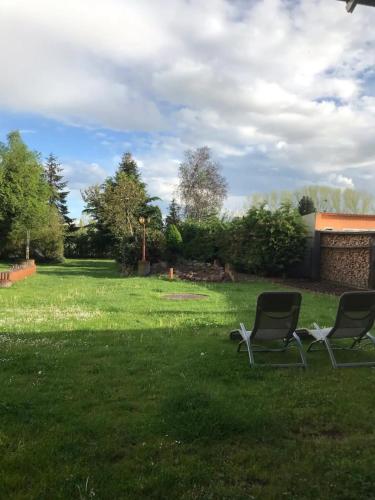 two chairs sitting in the grass in a yard at Familienhaus in Arnsdorf