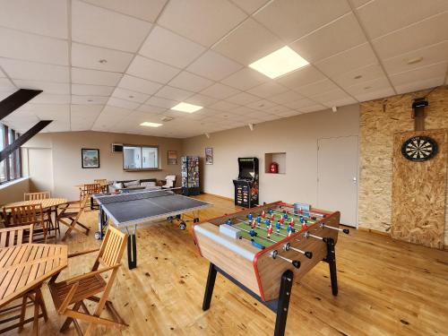 Cette chambre comprend une table de ping-pong et des chaises. dans l'établissement Le Clos Tranquille, à Gonneville-en-Auge