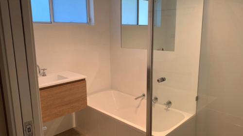 a bathroom with a shower and a tub and a sink at Pet Friendly Riverside Classic With Wifi in Hawks Nest