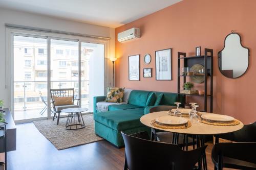 a living room with a green couch and a table at Harbor Apartments in Larnaca in Larnaka