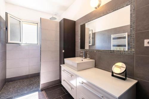 une salle de bain avec un lavabo et un miroir dans l'établissement Villa piscine 6 personnes-3 chambres-climatisée, à Biguglia