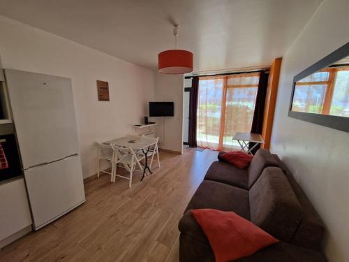 un salon avec un canapé et une table dans l'établissement Appartement à 100m Plage des Minimes avec internet, à La Rochelle