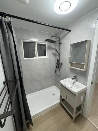a bathroom with a shower and a sink and a tub at Inntowne Motel in Hope