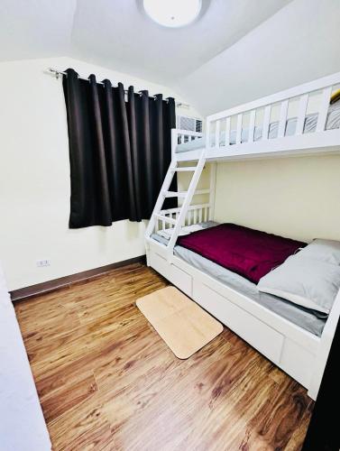 ein Schlafzimmer mit Etagenbett und Holzboden in der Unterkunft 3 Bedroom House near Davao Airport in Davao City