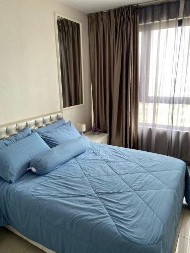 uma grande cama azul num quarto com uma janela em Orak Villa @ I-City Golden Triangle em Shah Alam