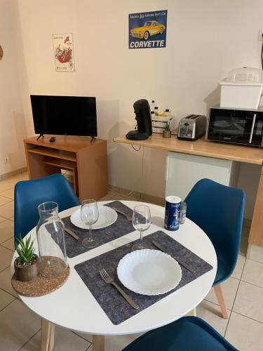 une table blanche avec deux plaques blanches dessus dans l'établissement Studios Les Courrèges, à Vézac