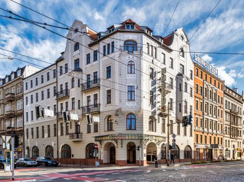 un gran edificio blanco en la esquina de una calle en Hotel Europejski Wrocław Centrum en Breslavia