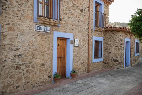a stone building with a door and a sign on it at CASA RURAL La Moranta in Herguijuela