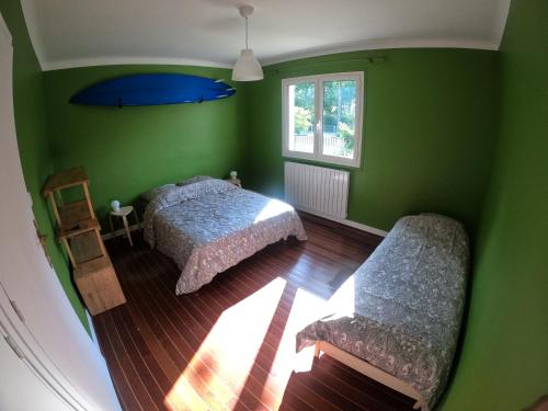 - une chambre verte avec 2 lits et une fenêtre dans l'établissement Surfhouse a proximité des spots de surf, à Capbreton