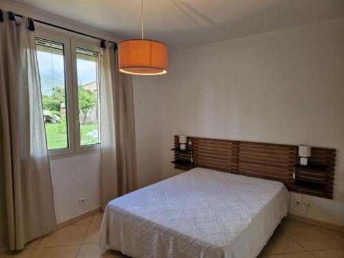 een slaapkamer met een bed en een groot raam bij Maison jumelée clôturée in Linguizzetta