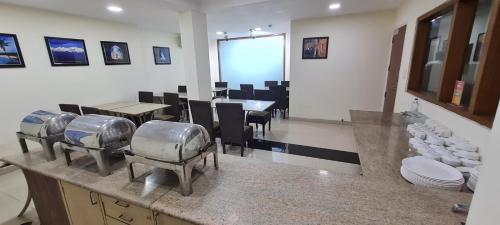 新德里的住宿－Hotel Divine Admire Opp Gurudwara Sahib in Taimoor Nagar-Friends Colony，厨房设有带桌椅的用餐室
