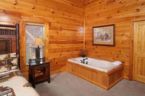 a bathroom with a tub in a log cabin at Hemlock Ridge 1713 in Gatlinburg