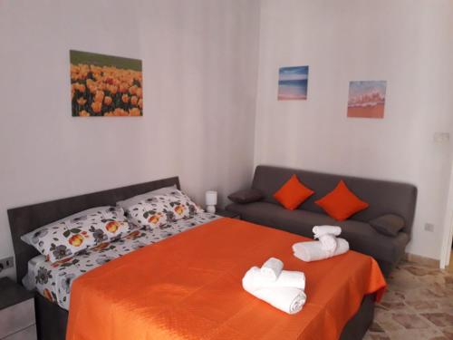 a bedroom with a bed and a couch at La casa di Ross in Casteldaccia