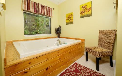 a bathroom with a large tub and a chair at Among The Clouds 2240 in Gatlinburg
