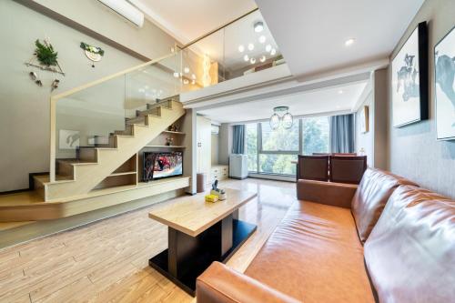 a living room with a couch and a staircase at Plesant Daily Rental Apartment in Hangzhou