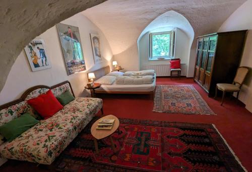 a living room with a bed and a couch at Ferienwohnung Ottmanach Josefhof in Pischeldorf