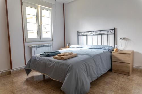 Un dormitorio con una cama con toallas. en Piso Turístico Las Nisas I, en Puerto de Vega
