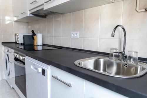una cocina con fregadero y encimera en Piso Turístico Las Nisas I, en Puerto de Vega