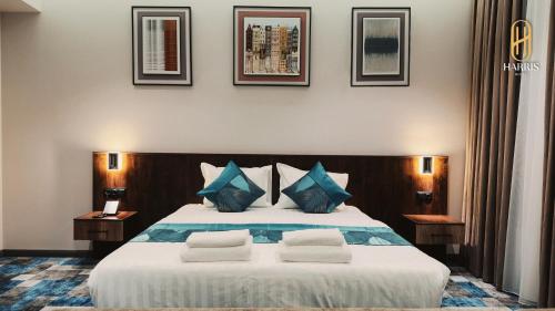 una camera da letto con un letto grande con cuscini blu di Harris Hotel a Tashkent