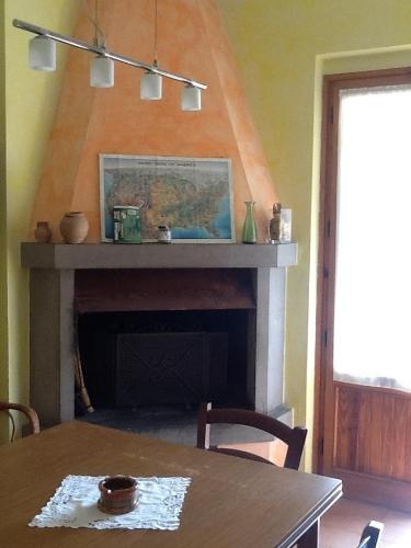a dining room with a table and a fireplace at B&B Casa Gori in Greve in Chianti