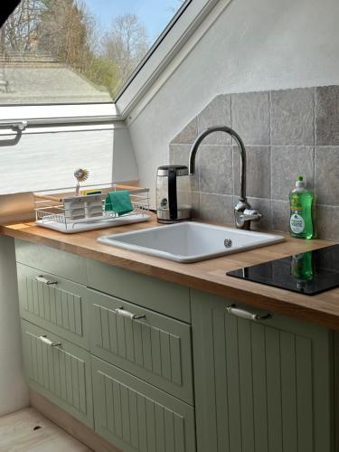 un comptoir de cuisine avec un évier et une fenêtre dans l'établissement Gite, à La Rosière