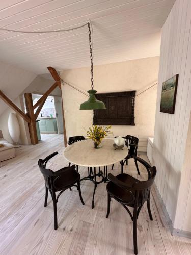 une table de salle à manger avec des chaises noires et une lumière verte dans l'établissement Gite, à La Rosière