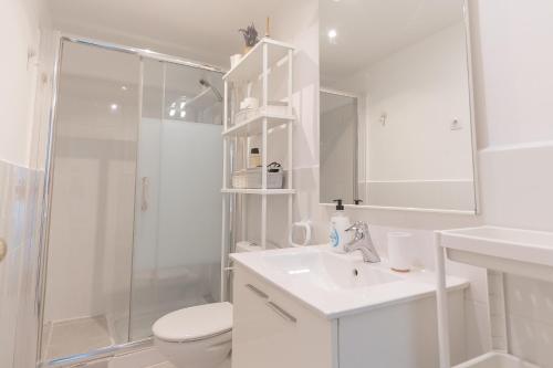 a white bathroom with a shower and a sink and a toilet at Clauhomes Oh La Lá in Tarragona