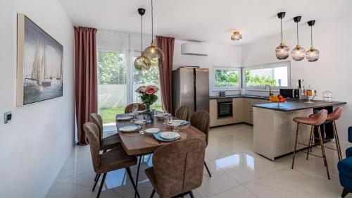 a kitchen and dining room with a table and chairs at Villa Bura in Barbat na Rabu