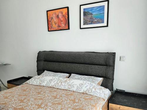 a bed in a bedroom with two pictures on the wall at Serene Three-Bedroom Retreat in Unforgettable Setting in Kérynia