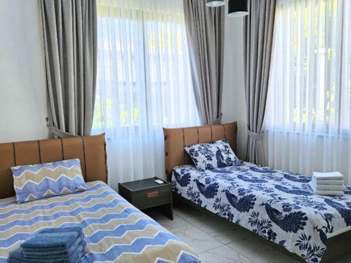 a bedroom with two beds and a window at Serene Three-Bedroom Retreat in Unforgettable Setting in Kérynia