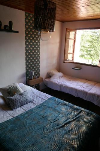 2 Betten in einem Zimmer mit Fenster und einem Bett sidx sidx sidx sidx in der Unterkunft Grand gîte au pays des lavandes in Aurel