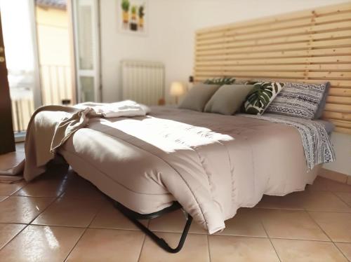 a bedroom with a large bed with a wooden headboard at Quick Home - Interno 45 in Biella