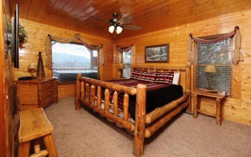 1 dormitorio con 1 cama en una cabaña de madera en Legacy Views and A Theater, en Sevierville